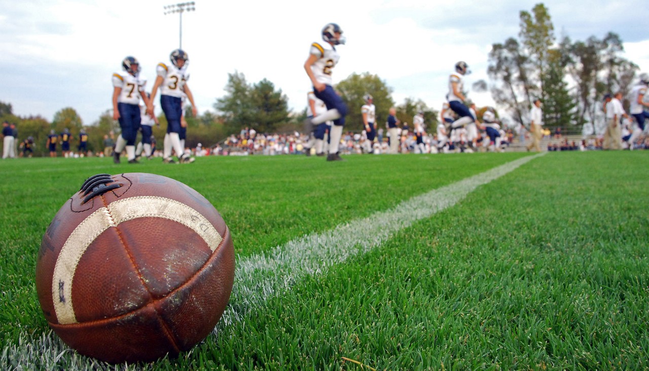 football players on field doing warm up routines